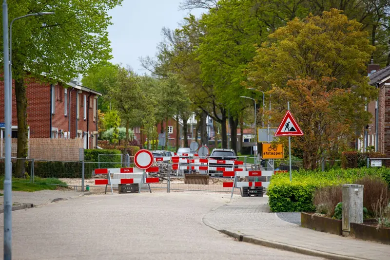Afgesloten straat met hekken en borden in een woonwijk